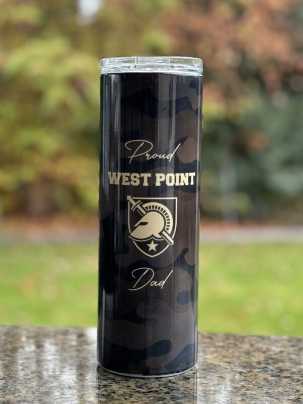 A black and gold west point dad candle sitting on top of a table.