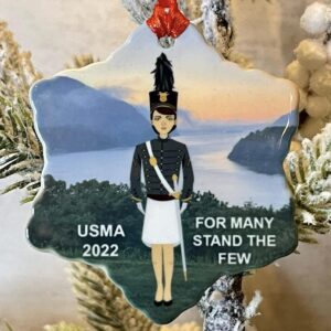 A christmas ornament with a soldier standing in front of the water.