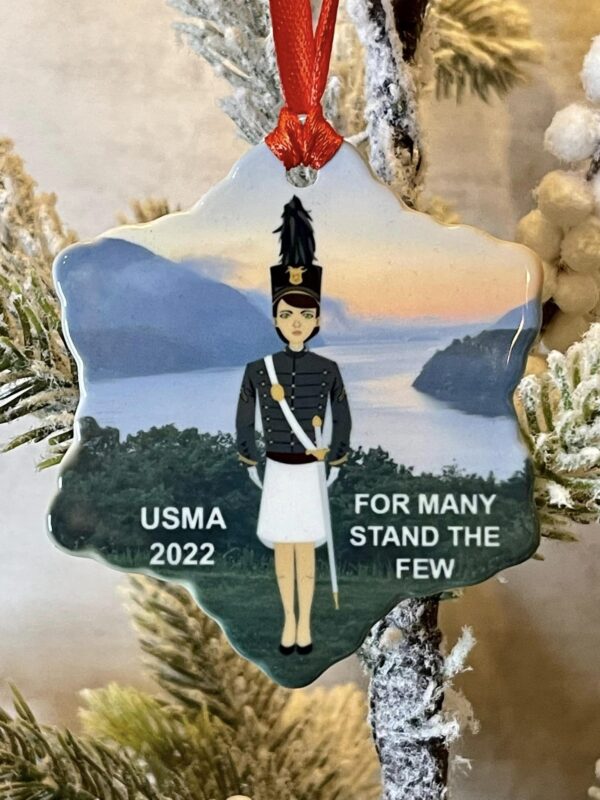 A christmas ornament with a soldier standing in front of the water.