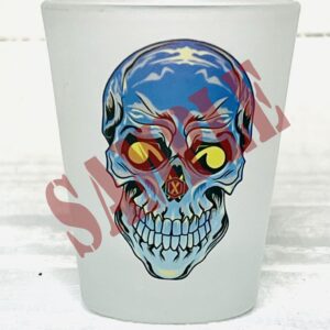 A frosted shot glass with a skull on it.