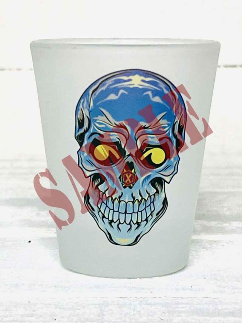 A frosted shot glass with a skull on it.