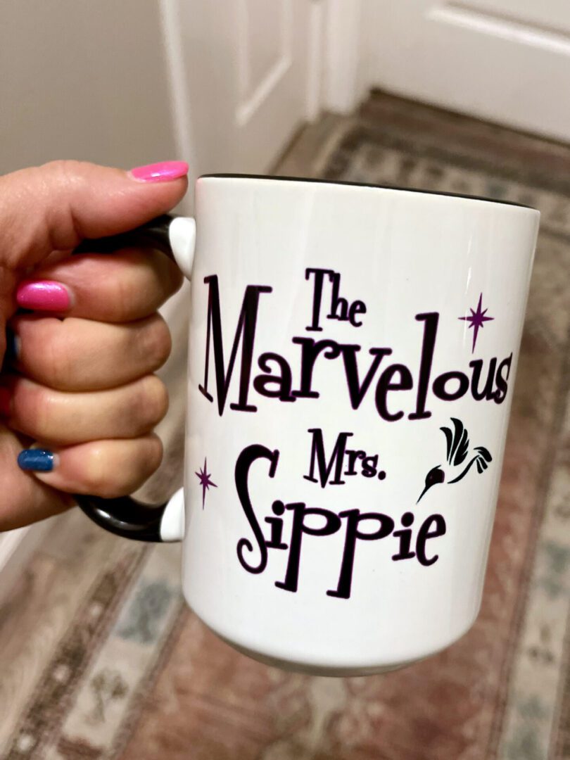 A woman holding the marvelous Mr. sippie logo cup